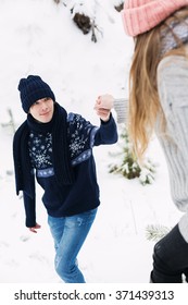 Holidays, Winter, Love And People Concept - Man Holding The Hand Of Woman Helping To Walk