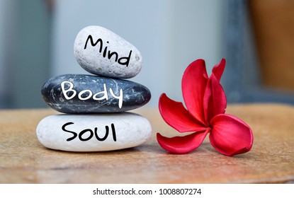 Holistic health concept of zen stones with deep red plumeria flower on blurred background. Text body mind soul. - Shutterstock ID 1008807274