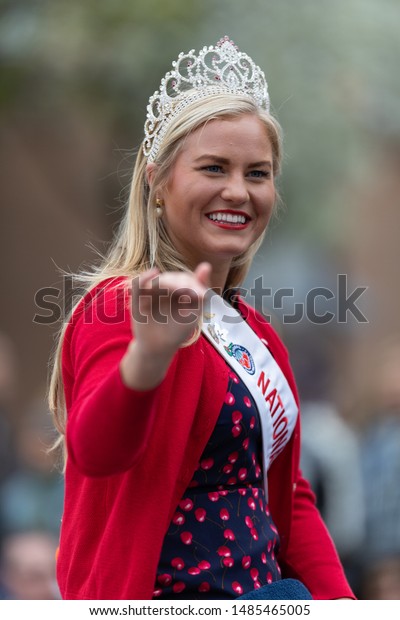 Holland, Michigan, USA - May\
11, 2019: Tulip Time Parade, Beauty queens, smiling and waving at\
the spectators, being transported on the back of a car during the\
parade