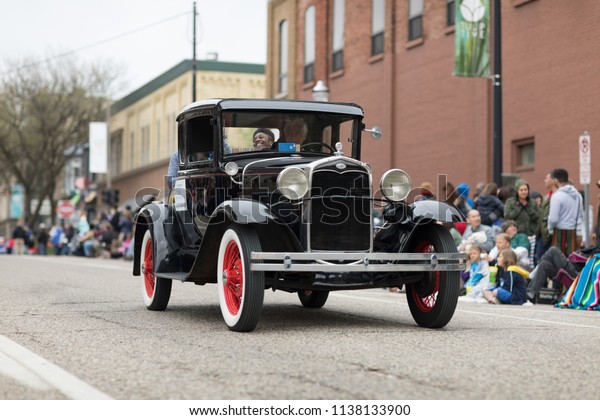 Holland, Michigan, USA - May 12, 2018 Old\
Classic Ford car going down the road at the Muziek Parade, during\
the Tulip Time\
Festival