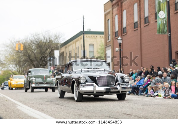 Holland, Michigan, USA - May 12, 2018 A group of\
classic cars go down the road at the Muziek Parade, during the\
Tulip Time Festival