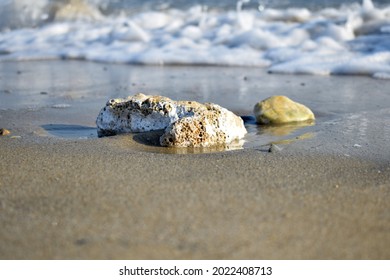 Hollow Rock Is Placed On The Sandy Beach And Sea.