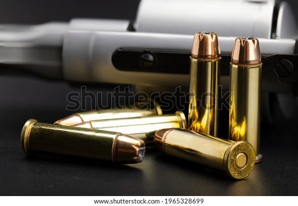 Hollow-point .38 Special bullets with revolver\
gun on black background , Classic bullets for revolver handgun ,\
more performance .38 special\
ammunition