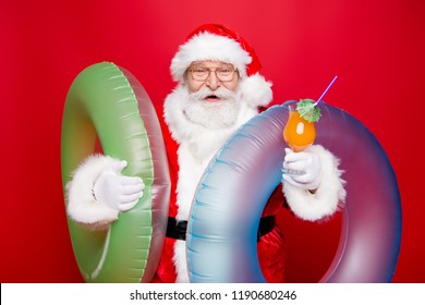 Holly jolly eve december noel. Careless kind aged mature Santa in spectacles tradition costume white beard isolated red background juicy vitamin beverage in hands look at camera prepare take trip - Powered by Shutterstock