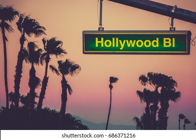 A Hollywood Blvd Sign At Sunset With Palm Trees In Los Angeles