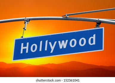 Hollywood Blvd Street Sign  And Mountains With Orange Sunset Sky.