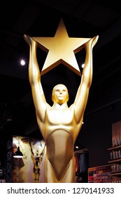 Hollywood, CA/ USA - July 26, 2018: Golden Oscar Statue Holding Gold Star. Golden Award Or Trophy Is Symbol Of Success And Victory Concept 