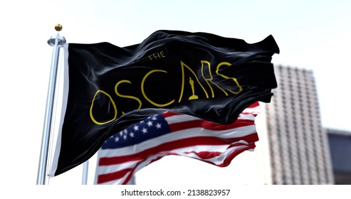 Hollywood, CA, USA, March 2022: The Flag With The Academy Awards Logo Waving With The American Flag Blurred In The Background. The Academy Award, Aka Oscar, Is The World's Most Prestigious Film Award