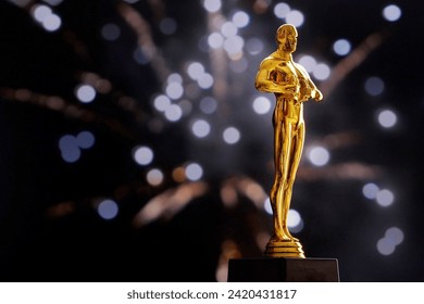 Hollywood Golden award statue on fireworks background with copy space. Success and victory concept.