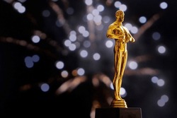 Hollywood Golden Oscar Academy Award Statue On Fireworks Background With Copy Space. Success And Victory Concept.