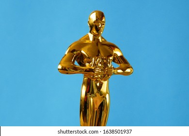 Hollywood Golden Oscar Academy award statue on blue background. Success and victory concept.
