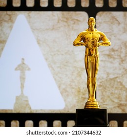 Hollywood Golden Oscar Academy award statue on old film background with copy space. Success and victory concept.