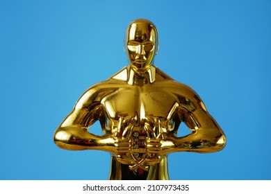 Hollywood Golden Oscar Academy award statue on blue background with copy space. Success and victory concept.