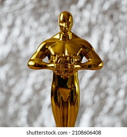 Hollywood Golden Oscar Academy award statue on blue background with copy space. Success and victory concept.