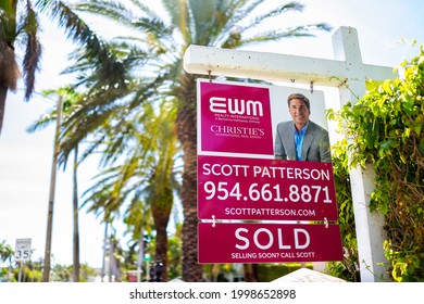 Hollywood, USA - May 6, 2018: Closeup Of Red Real Estate Agent Sign Text On Street During Sunny Day In Florida East Coast In North Miami Beach