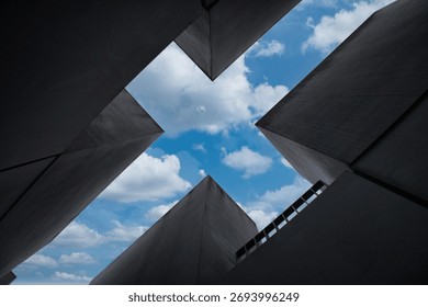 Holocaust Memorial abstract view - Dramatic low-angle abstract view looking up through the massive concrete stelae of the Holocaust Memorial in Berlin to the blue sky above.