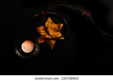 Holocaust Memory Day. Arbed Wire And Burning Candle On Black Background