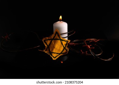 Holocaust Memory Day. Arbed Wire And Burning Candle On Black Background