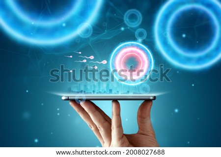 A hologram of fertilization of an egg by sperm cells in a smartphone. Modern technologies, Pregnancy, infertility treatment, motherhood.