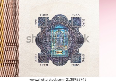 Holographic on a fifty euro banknote with iridescent reflective details in the foil to prevent fraud with paper money. Close up  for economy content