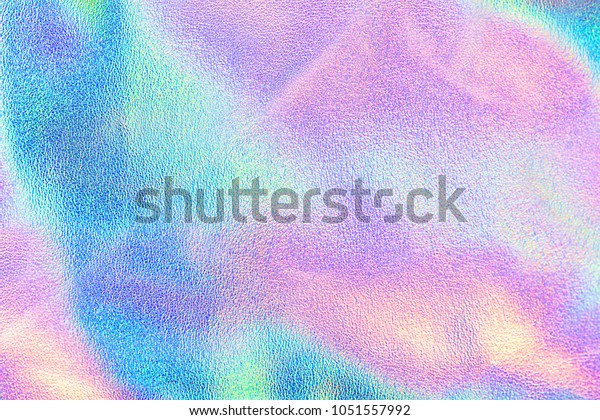 Holographic real\
texture in blue pink green colors with scratches and\
irregularities. Holographic color wrinkled foil. Holographic\
rainbow foil abstract\
background.