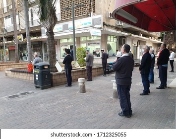 HOLON, ISRAEL. April 23, 2020. Religious Jewish People Praying Outside The Synagogue Due To The Novel Coronavirus Quarantine Limitations Observing Distance. COVID-19 Quarantine Concept Image.