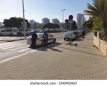 HOLON, ISRAEL. February 22, 2021. Police Officer Making A Fine Report To A Woman Walking In The Street Without A Safety Mask. Israel Pandemic Quarantine Fine Concept Image.