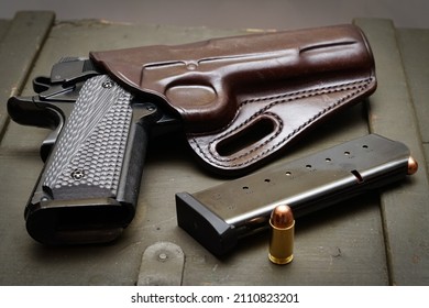 Holstered 45acp pistol with magazine and one round on the outside.