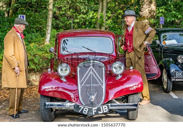 Holt, Norfolk, UK – September 14 2019.\
Two old men dressed in 1940s style clothing beside a vintage Austin\
car at the annual forties weekend in Holt\
Norfolk