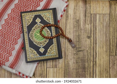 Holy Al Quran with written arabic calligraphy meaning of Al Quran and rosary beads on wooden background. Islamic concept. - Powered by Shutterstock