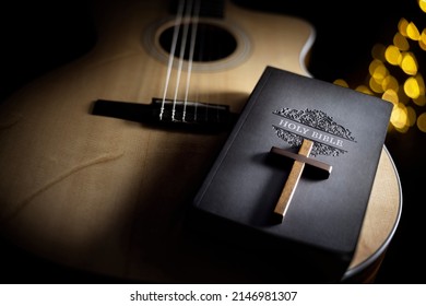 Holy Bible with acoustic guitar and religious crucifix cross, gospel music concept - Shutterstock ID 2146981307