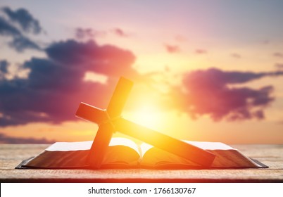 Holy Bible Book And Christian Cross On The Sky Background