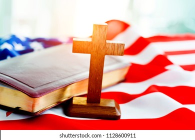 Holy bible with a cross on american flag.