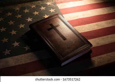 Holy Bible with a cross on top over a vintage old american flag.