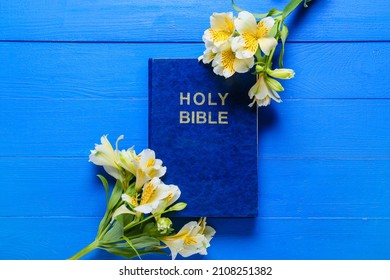 Holy Bible With Flowers On Blue Wooden Background