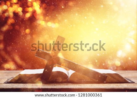 Holy Bible on the background of the Christian cross and the life-giving divine light. The hope of mankind for salvation. The way to God through prayer. The Resurrection and Rapture of Jesus.