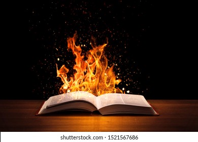 Holy Bible On Fire On A Wooded Desk.