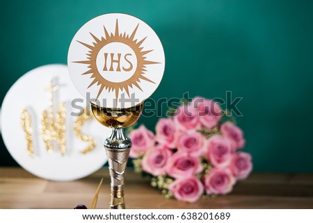 Holy Communion chalice flowers and grapes on wooden table