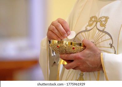 Holy host in the hands of the priest on the altar during the celebration of the mass and empty space for text