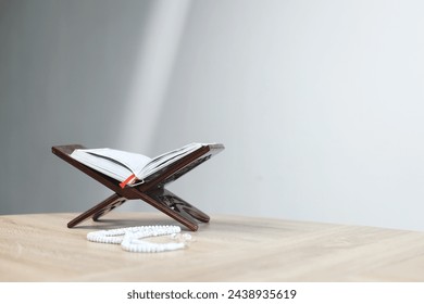 Sagrado Corán en mesa de madera con haz de luz para el Ramadán y el fondo de Eid