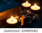 Holy Rosary, Bible and burning candles on dark background. ideas. Religion concept.