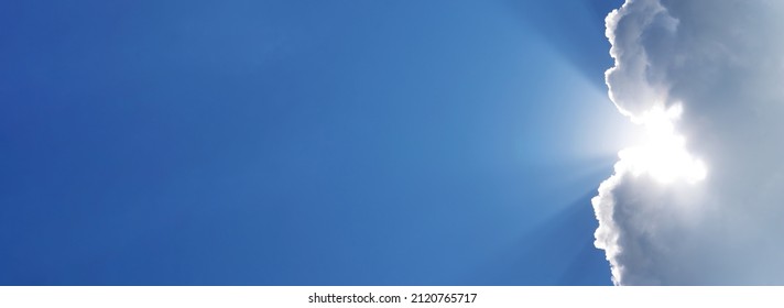 Holy spirit long banner. Blue sky with the rays of the sun coming out of a white cloud. Religious background with sky and sunbeams. Sunny clear weather background for weather forecast and meteorology. - Shutterstock ID 2120765717