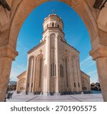 Holy Trinity Cathedral, also known as Sameba, framed by a stone arch in Tbilisi, Georgia