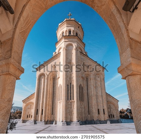 Holy Trinity Cathedral, also known as Sameba, framed by a stone arch in Tbilisi, Georgia