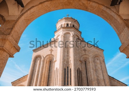 Holy Trinity Cathedral, also known as Sameba, framed by a stone arch in Tbilisi, Georgia