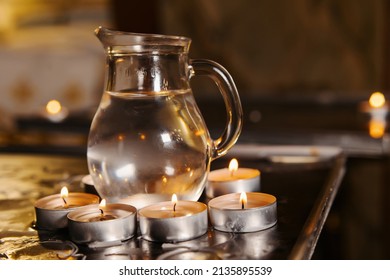 Holy water is heated by candles on a pedestal in a church for the rite of christening of a child. Faith in the baptism of Jesus Christ. Holy water.