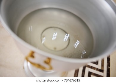 holy water in a metal bowl in an Orthodox church. The Rite of Baptism