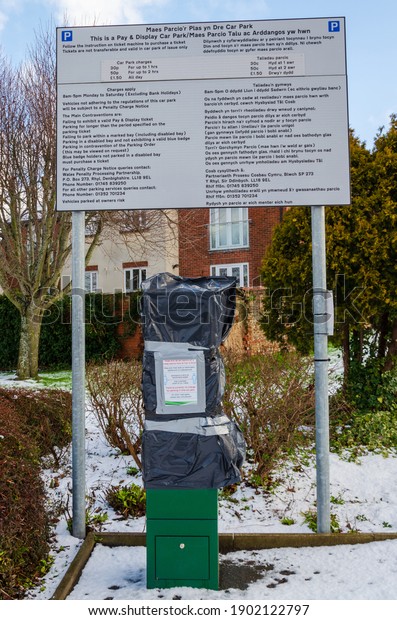 Holywell, Flintshire; UK: Jan 25, 2021: Due to\
the corona virus pandemic, charging for car parking has been\
suspended in Plas Yn Dre Car Park. The payment machine has been\
covered with black\
plastic.