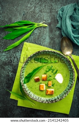 Homade bear leek soup or ramson soup with crouton and sour cream 