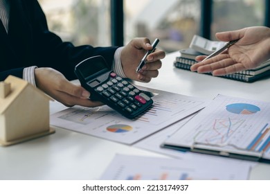 Home agents talk to new homebuyers and offer good interest rates and calculate clients on mortgage financing to help them decide on real estate ideas with insurance. - Shutterstock ID 2213174937